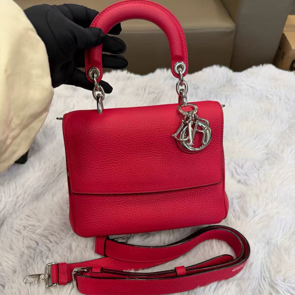 Dior's classic fuchsia pebbled leather can be carried by hand, crossbody, or over the shoulder.