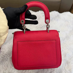 Dior's classic fuchsia pebbled leather can be carried by hand, crossbody, or over the shoulder.